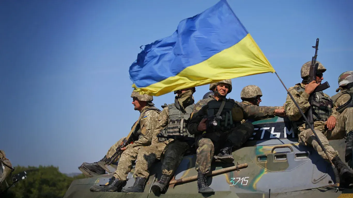 Soldiers on an armoured vehicle carrying a Ukrainian flag